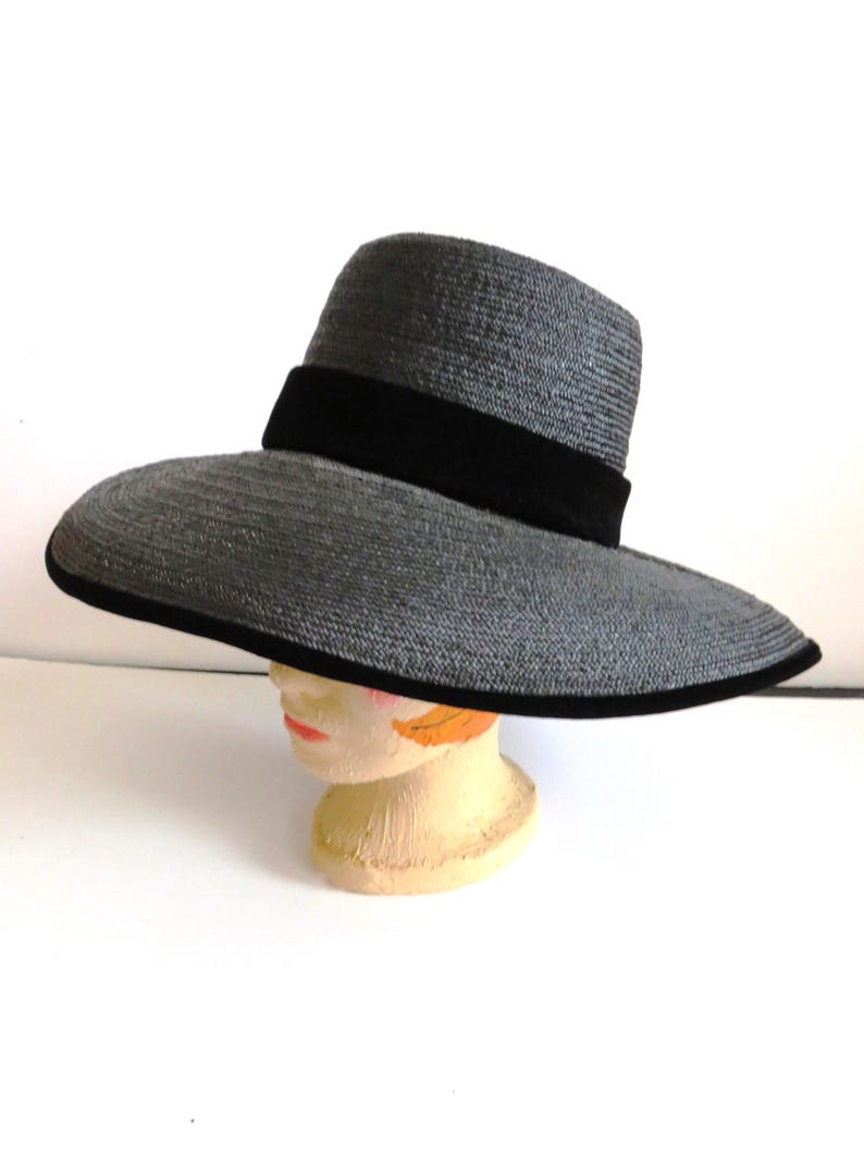 May include: A wide-brimmed gray straw hat with a black velvet band.