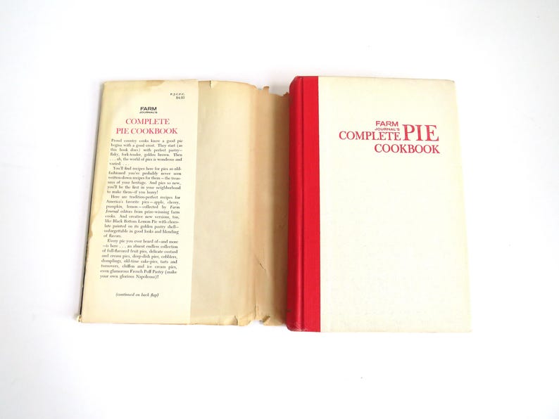 Puede incluir: Un libro de cocina vintage titulado "Farm Journal's Complete Pie Cookbook" con una encuadernaci&oacute;n roja. El libro est&aacute; abierto en la contraportada, que tiene texto que describe el contenido del libro.
