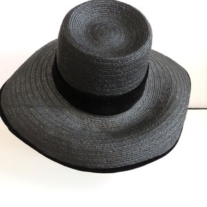 May include: A black wide-brimmed straw hat with a black velvet band.