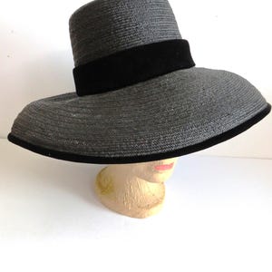 May include: A wide-brimmed black straw hat with a black velvet band.