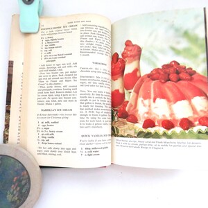 May include: An open vintage cookbook page featuring a recipe for Coconut Honey Ice Cream and Mariella's Ice Cream. The right page displays a color photograph of a molded strawberry sherbet dessert topped with fresh strawberries and two tall glasses.