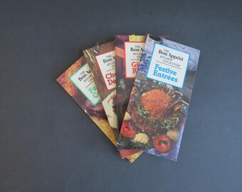 May include: A set of four rectangular recipe booklets from The Bon Appétit Kitchen Collection, fanned out to display covers titled Festive Entrées, Gift Kitchen, Chocolate Desserts, and Family Cooking, each featuring colorful food photography.