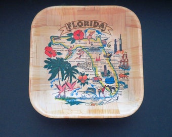 Puede incluir: Una bandeja de madera con un mapa de Florida impreso en ella. El mapa muestra las principales ciudades y puntos de interés, incluyendo Orlando, Miami y Tampa. La bandeja es de color marrón claro y tiene un patrón tejido.