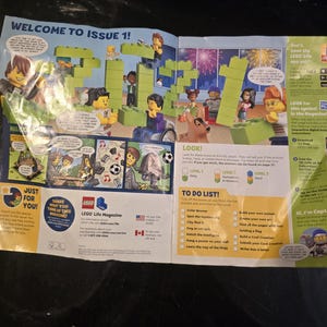 May include: A LEGO Life Magazine issue 1 spread featuring a large green brick construction of the year 2021, various minifigures, comic strips, a to-do list, and informational text about the LEGO Life app, all printed on glossy paper.