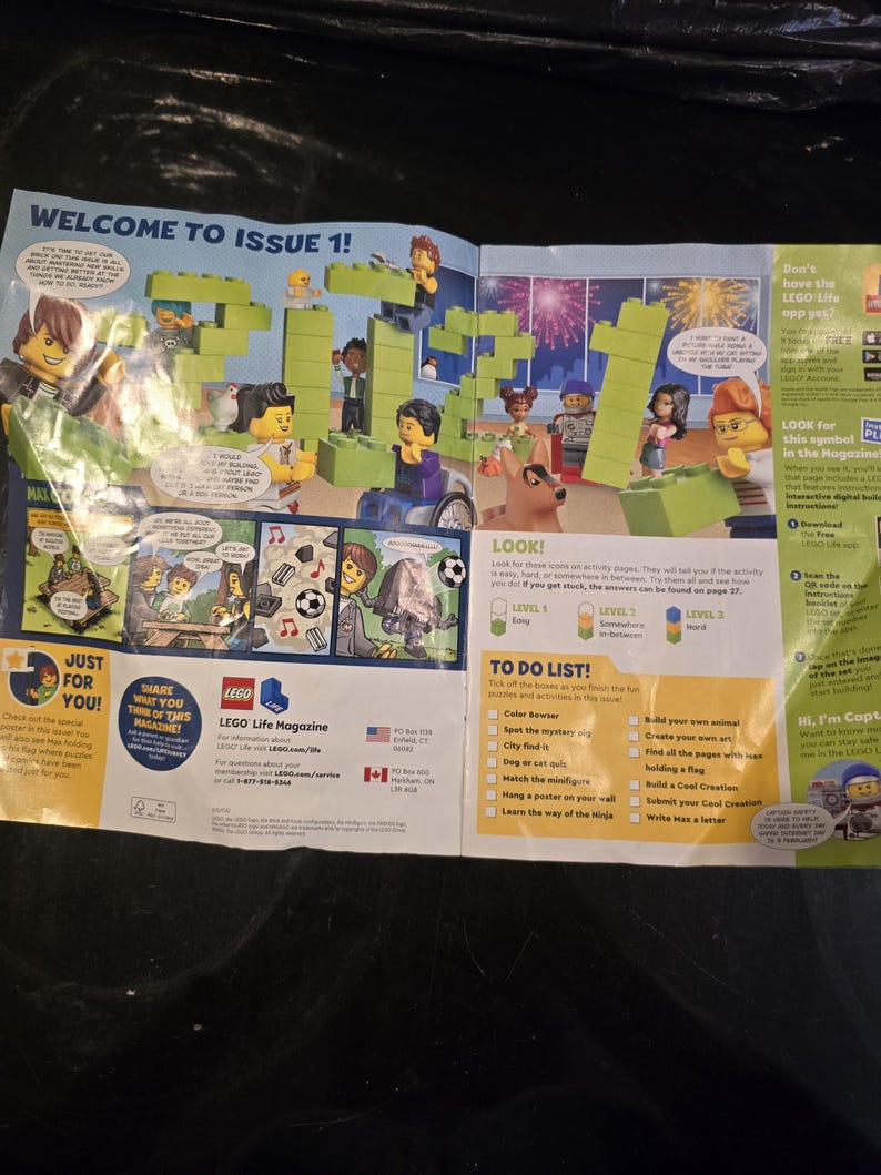 May include: A LEGO Life Magazine issue 1 spread featuring a large green brick construction of the year 2021, various minifigures, comic strips, a to-do list, and informational text about the LEGO Life app, all printed on glossy paper.