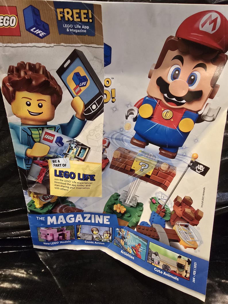 May include: A promotional LEGO Life magazine featuring a LEGO minifigure holding a smartphone, a LEGO Mario figure jumping above a brick-built question block, and various smaller images showcasing new models, comic action, activities, and cute animals.
