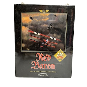 May include: A black box featuring a vintage image of biplanes in flight, with a red and white plane in the foreground. The title "Red Baron" is displayed in ornate red lettering, with "Hall of Fame - Computer Gaming World" below.