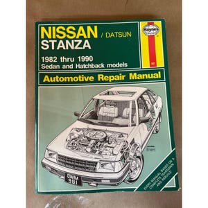 Puede incluir: Manual de reparación automotriz Haynes verde y blanco para modelos Nissan Stanza de 1982 a 1990. La portada presenta una ilustración de un coche con el motor expuesto. El título y los años del modelo son visibles.