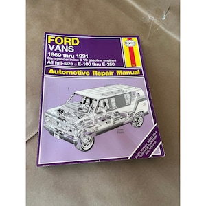 Può includere: Un manuale di riparazione automobilistica Haynes per Ford Vans dal 1969 al 1991. La copertina viola e bianca presenta un'illustrazione dettagliata di un furgone e informazioni sui motori e i modelli coperti.