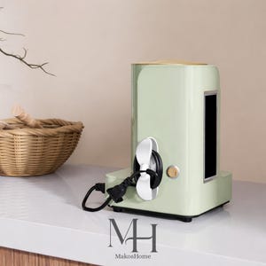 Op de afbeelding: Een witte keramische mok met een zwart handvat en de tekst "But First, Coffee" in een zwarte, handgeschreven lettertype. De mok staat op een wit oppervlak.