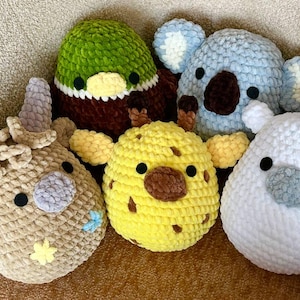 Peut inclure: Collection de cinq peluches d'animaux au crochet faites à la main. Les peluches comprennent un canard, un koala, une girafe, une licorne et un animal à cornes. Chaque peluche a un code couleur et un design uniques.