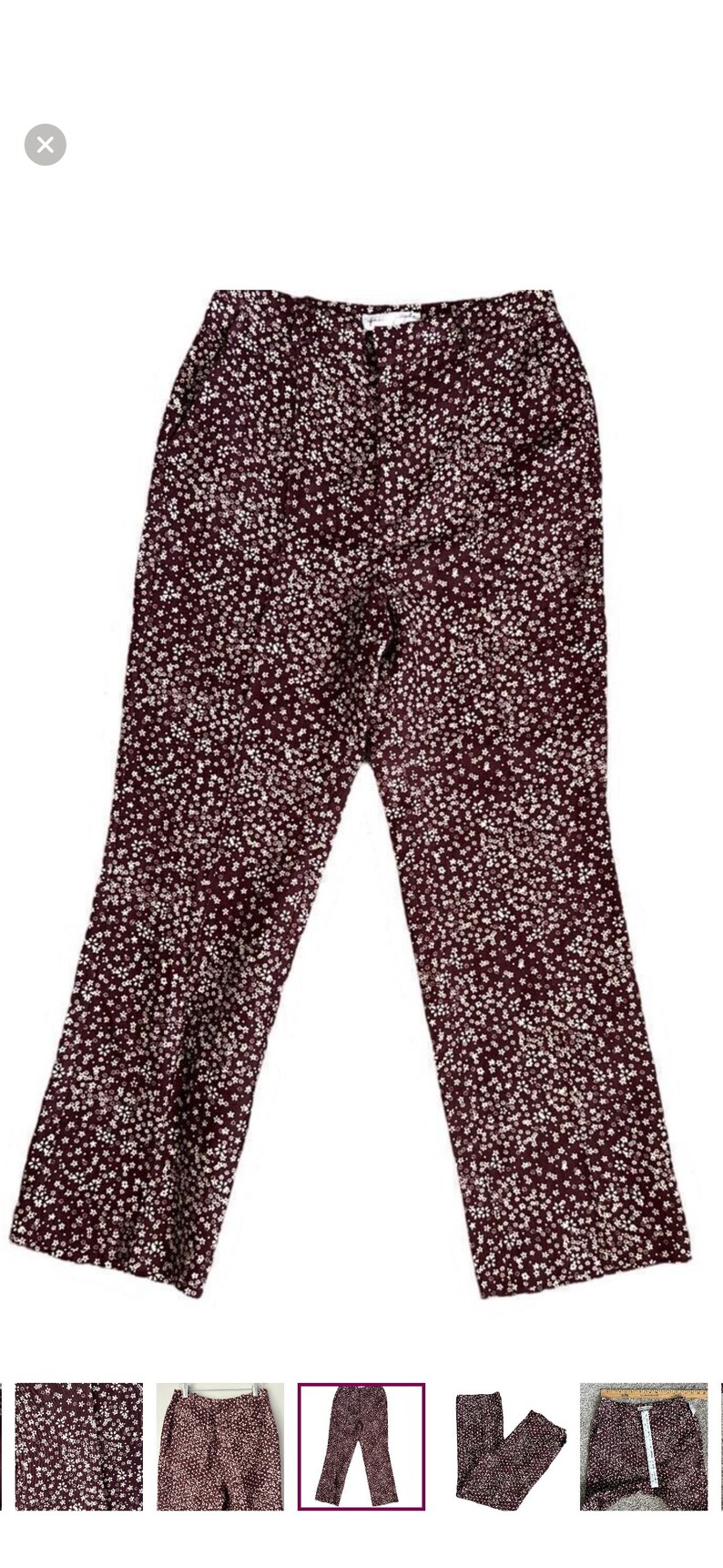 May include: Burgundy-colored pants with a white floral pattern. The pants have a high waist and a flared leg. The fabric appears to be a lightweight material, suitable for warmer weather. The pants are displayed on a white background.
