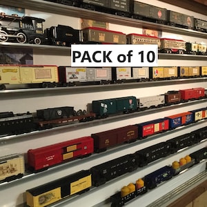 May include: A collection of model train cars and a locomotive displayed on shelves. The train cars are in various colors, including red, yellow, green, and black. The text "PACK of 10" is visible in the image.