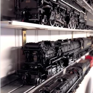 May include: A collection of black model train engines on shelves. The engines are detailed with silver accents and have numbers on the side. The shelves are made of metal and have a white background.