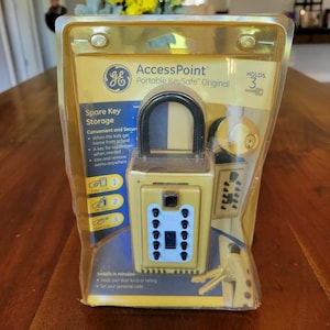 May include: A GE AccessPoint Portable KeySafe Original in its original plastic packaging. The tan-coloured lock box features a black shackle, a white keypad with black buttons, and text indicating it holds 3 keys. The packaging includes instructions.