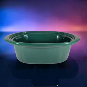 May include: A deep, oval-shaped ceramic baking dish with a smooth, dark forest green glazed finish. The vessel features a wide, flat rim extending outward from the top edge, providing a sturdy grip for handling the container during use.