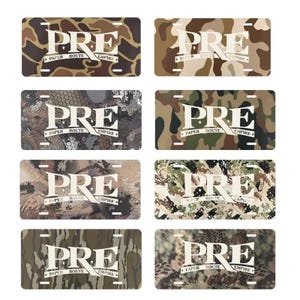 May include: Eight license plates with camouflage patterns in shades of brown, green, and gray. Each plate features the word "PRE" in white, with "PAPER ROUTE EMPIRE" below.