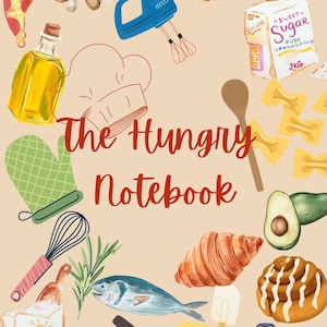 May include: A notebook cover with a culinary theme, featuring illustrations of food items like pizza, mushrooms, and a croissant. The title "The Hungry Notebook" is displayed in red script. Other items include a whisk, a blue hand mixer, and a bag of sugar.