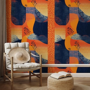 May include: Abstract wallpaper with a repeating pattern of orange, yellow, and navy blue shapes. A straw hat rests on a white cushioned chair. A small woven stool holds an open book.