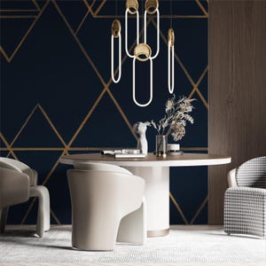 May include: A modern dining room with a navy blue geometric wallpaper and a round table. The room features white chairs, a patterned accent chair, and a unique light fixture with gold accents. Decorative vases and dried flowers add to the decor.