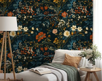 May include: A dark floral wallpaper featuring a dense pattern of orange, white, and yellow flowers with green and blue foliage. The wallpaper is the backdrop for a white chaise lounge with pillows, a side table, and a floor lamp.