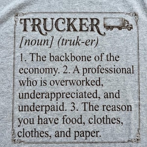 May include: Gray t-shirt with the word "TRUCKER" in a decorative font, accompanied by a definition. The definition includes the phrase "backbone of the economy" and a truck graphic.