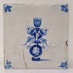 Antieke Nederlandse Delftse tegel, 18e eeuw, handgeschilderd met blauw-witte tulpenbloemen.