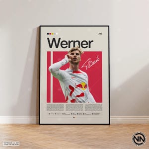 May include: A framed poster featuring the name "Werner" in large text, with a portrait of a soccer player in a white and red jersey. The poster includes a signature and a red background.