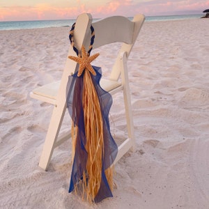 May include: A white folding chair with a blue and tan fabric starfish decoration tied to the back.
