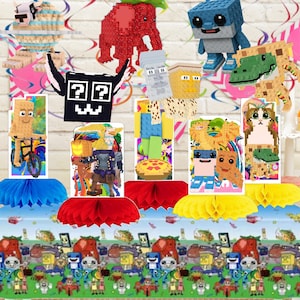 May include: A collection of pixelated character centerpieces featuring various blocky figures, including a red elephant, a blue creature, and a cat, displayed on colorful honeycomb paper bases with a matching patterned tablecloth underneath.