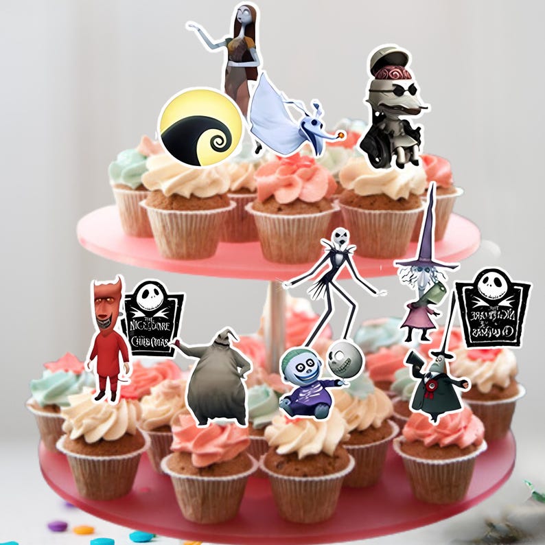 Pu&ograve; includere: Un supporto per torte rosa a due livelli contiene cupcakes ricoperti di glassa bianca e rosa. I cupcakes sono decorati con decorazioni di personaggi di The Nightmare Before Christmas, tra cui Jack Skellington e Sally.