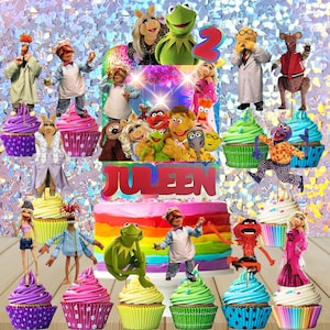 May include: A colorful birthday cake and cupcakes featuring Muppet characters. The cake has a rainbow design with the name "Juleen" on it. The cupcakes are decorated with various Muppet figures.