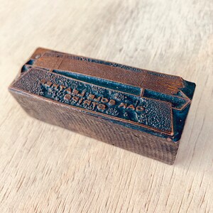 May include: A vintage wood printing block with the text "OAK SOLE LEATHER" in gold lettering.