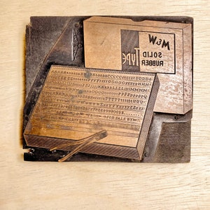 May include: A vintage wood printing block with a metal typeface set. The block is labelled "Rubber Solid Type" and "W.J.M.". The typeface includes the alphabet, numbers, and punctuation marks.