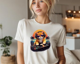 May include: Cream-colored t-shirt featuring a cartoon cat DJ wearing sunglasses and headphones, set against a retro sunset backdrop with palm trees. The cat is positioned behind a turntable. The shirt is a casual wear item.