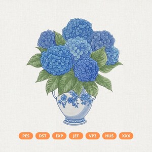 May include: An embroidered design of blue hydrangea flowers in a white and blue vase. The flowers are a vibrant blue, with green leaves. The vase has a blue floral pattern. The design is on a light beige background.