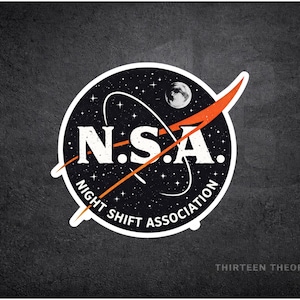 May include: A circular sticker featuring a design reminiscent of the NASA logo, but with the text "N.S.A. NIGHT SHIFT ASSOCIATION." The design includes a starry background, a crescent moon, and an orange swoosh. The sticker is on a dark gray textured background.