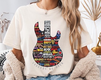 May include: Cream-colored t-shirt featuring a guitar-shaped graphic filled with rock band logos, including AC/DC, Metallica, and The Who. The words "LEGENDS OF ROCK" are printed below the guitar design. The shirt is a casual, unisex style.