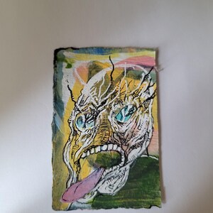 Puede incluir: Pintura abstracta de un rostro grotesco con la boca muy abierta y una larga lengua rosa. La cara es amarilla y blanca con ojos azules y líneas negras. El fondo tiene colores amarillo, rosa, verde y azul.