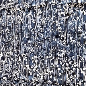 May include: A fabric with a repeating pattern of white bamboo stalks and leaves against a dark blue background. The design has a batik-like appearance, with the white lines contrasting against the darker hues. The overall effect is a natural, organic theme.