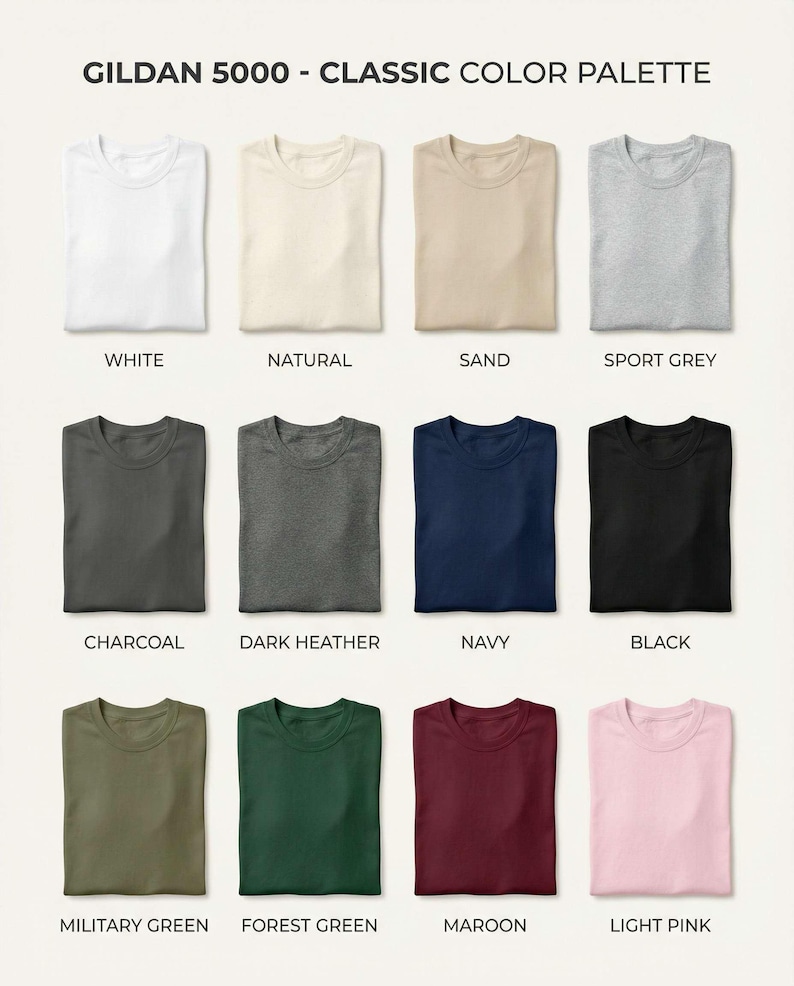 May include: A Gildan 5000 classic color palette chart displaying twelve folded t-shirts in white, natural, sand, sport grey, charcoal, dark heather, navy, black, military green, forest green, maroon, and light pink with corresponding labels.