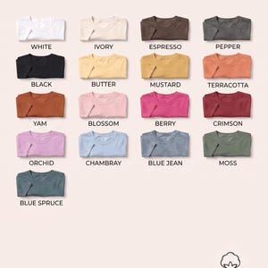 Może przedstawiać: Paleta kolor&oacute;w koszulek Comfort Colors 1717, przedstawiająca siedemnaście złożonych koszulek w r&oacute;żnych odcieniach, w tym biały, kość słoniowa, espresso, pieprz, czarny, masło, musztarda, terakota, ignam, kwiat, jagoda, karmazyn, orchidea, chambray, niebieski dżins, mech i niebieski świerk.