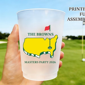 May include: A translucent plastic cup featuring a yellow map of the United States with a green outline and a red flag on a pole. The text reads THE BROWNS, MASTERS PARTY 2026, and PRINTED & FULLY ASSEMBLED. The cup has a wide rim and tapered base.