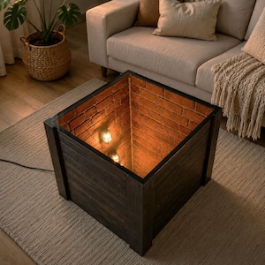 Peut inclure: Une table basse carrée avec des panneaux extérieurs en bois foncé et un plateau en verre. L'intérieur présente un espace creux bordé de murs en briques rouges et deux petits luminaires de style cage diffusant une lueur orange et chaude.