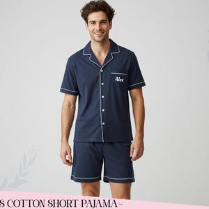 Op de afbeelding: Marineblauwe korte pyjamaset met witte bies. De overhemd met knopen heeft korte mouwen en een borstzak met de naam "Alex" in het wit geborduurd. De shorts hebben bijpassende witte bies. De tekst onderaan luidt "~MENS COTTON SHORT PAJAMA~".