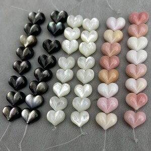 Puede incluir: Filas de cuentas en forma de corazón en varios colores, incluyendo negro, blanco, rosa y melocotón. Las cuentas tienen un acabado brillante y están ensartadas. Adecuadas para la fabricación de joyas y proyectos de artesanía.