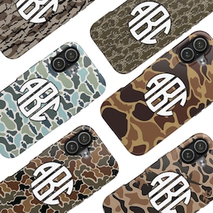 May include: A collection of phone cases with camouflage patterns in various colors, including green, brown, and blue. Each case features a white monogram design with the letters "AB" and "C". The cases have a glossy finish and are designed for a smartphone.