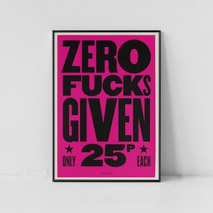 May include: A framed poster with a vibrant pink background and bold black text. The text reads "ZERO FUCKS GIVEN" in large capital letters, with "ONLY 25 EACH" below. Two stars flank the price.