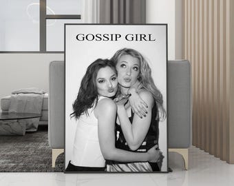 May include: Black and white framed print featuring two women posing for a photo. The print has the words "GOSSIP GIRL" at the top. One woman is wearing a white tank top, and the other is wearing a black top.