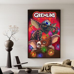 Puede incluir: Un p&oacute;ster enmarcado con la palabra "Gremlins" en rojo y blanco. La obra de arte representa a dos Gremlins, uno con gafas 3D, con luces de colores y un fondo rojo.